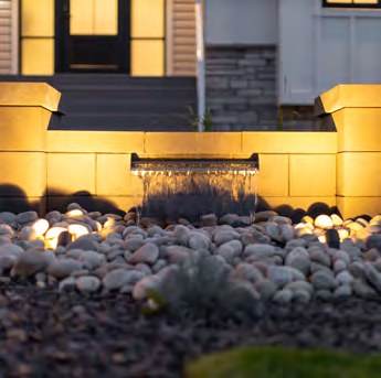 Retaining wall lit at night with integrated landscape lighting